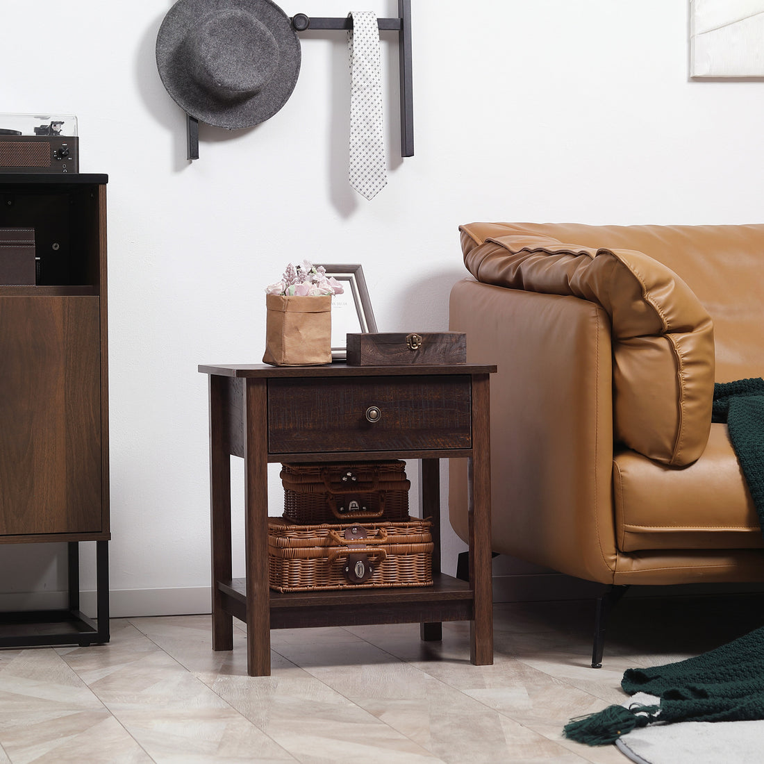 Wooden side table with decorative items next to a brown leather sofa.