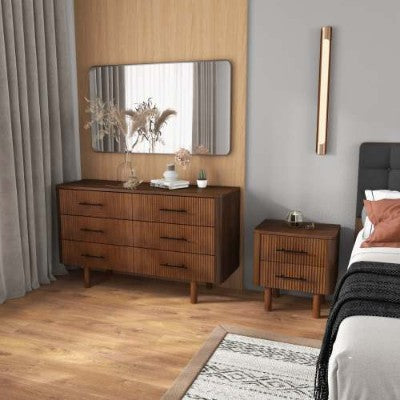 Wooden dresser with mirror in a bedroom setting