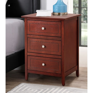 Wooden nightstand with three drawers next to a bed in a bedroom setting.