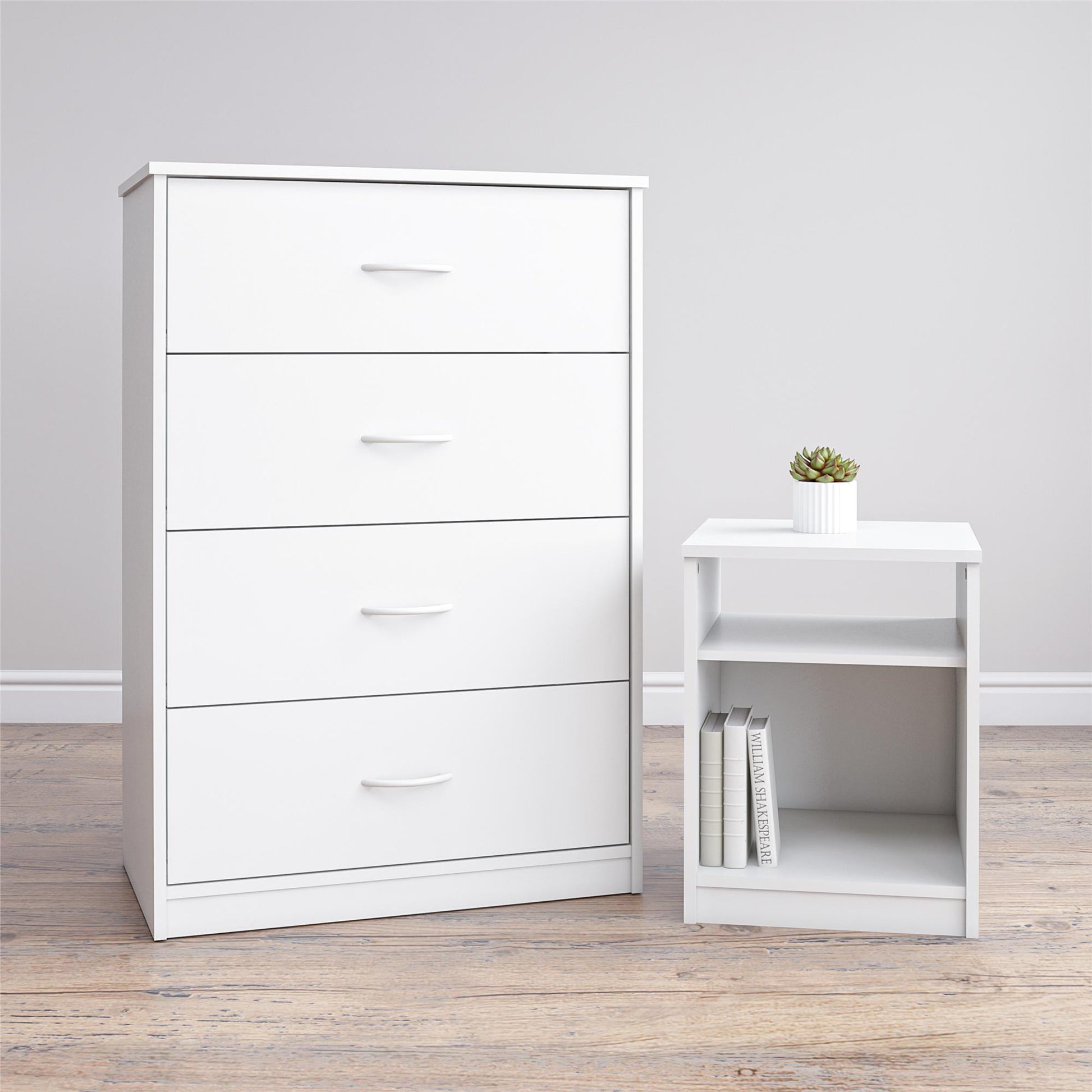 White dresser with multiple drawers next to a white side table with a plant on a wooden floor.