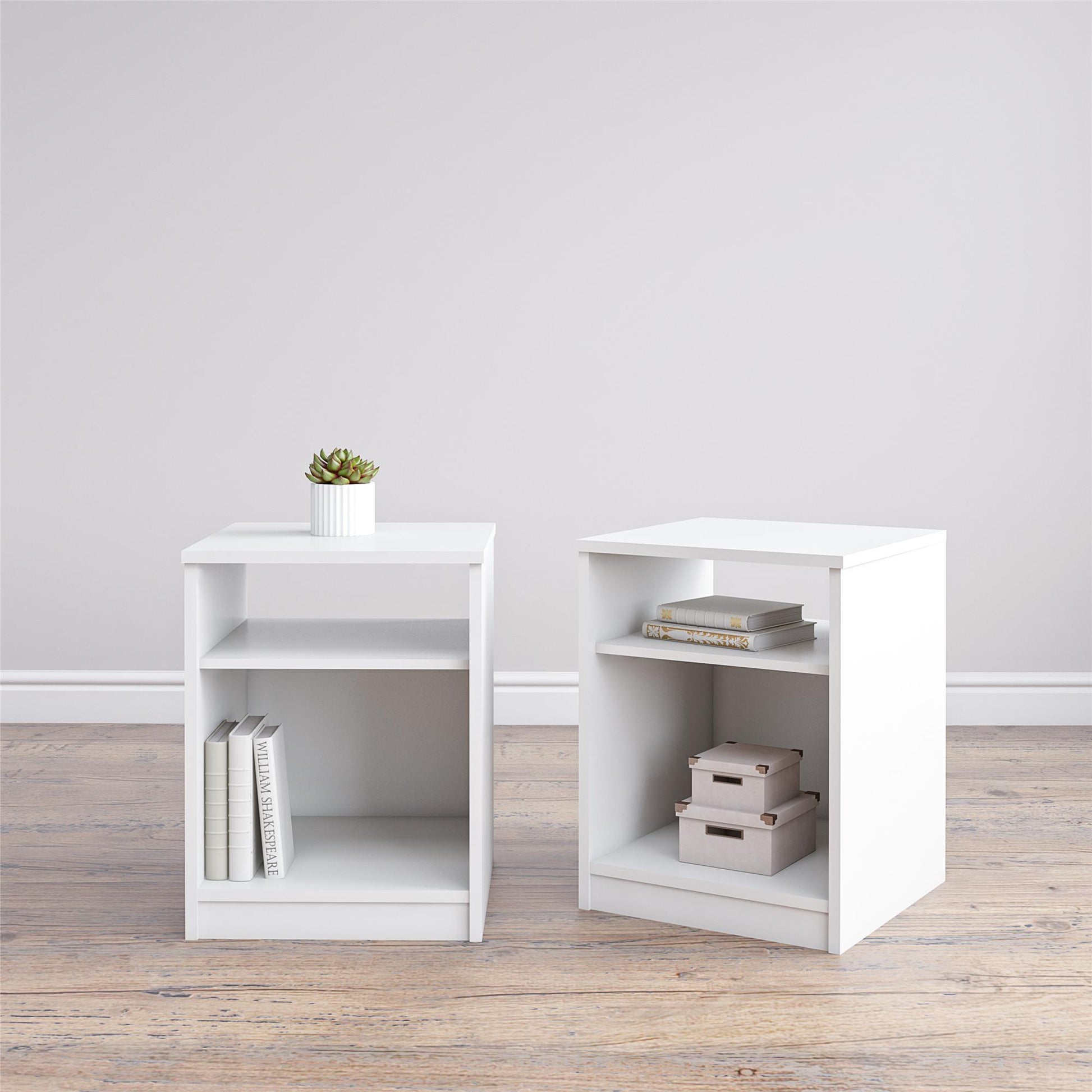 Two white side tables with shelves against a light gray wall.