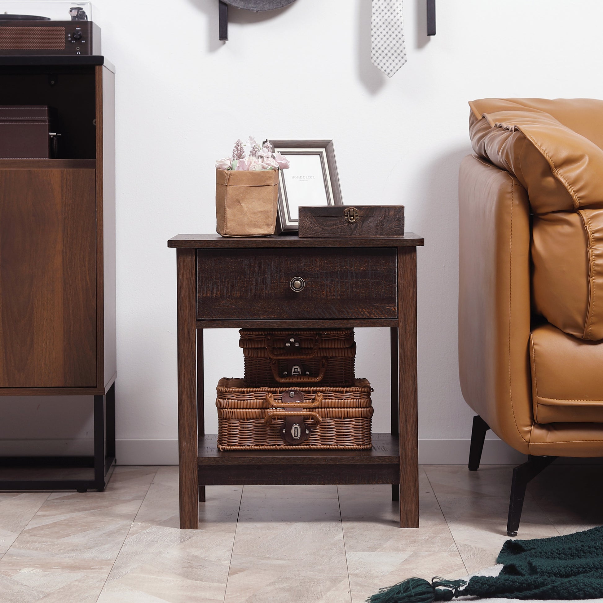 Wooden side table with decorative items next to a brown sofa in a room.