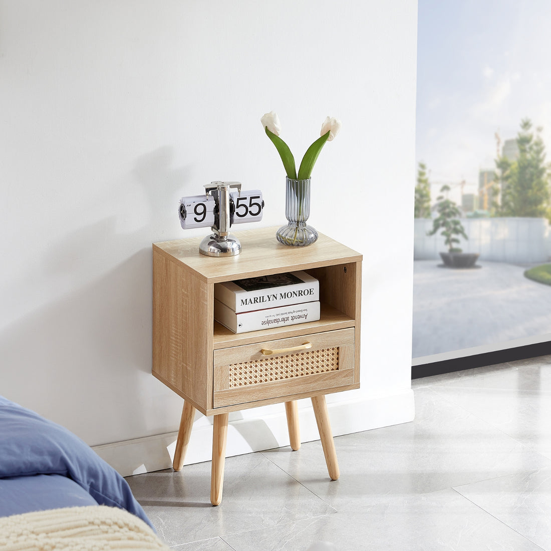 Wooden nightstand with books, a vase, and a clock in a room setting.